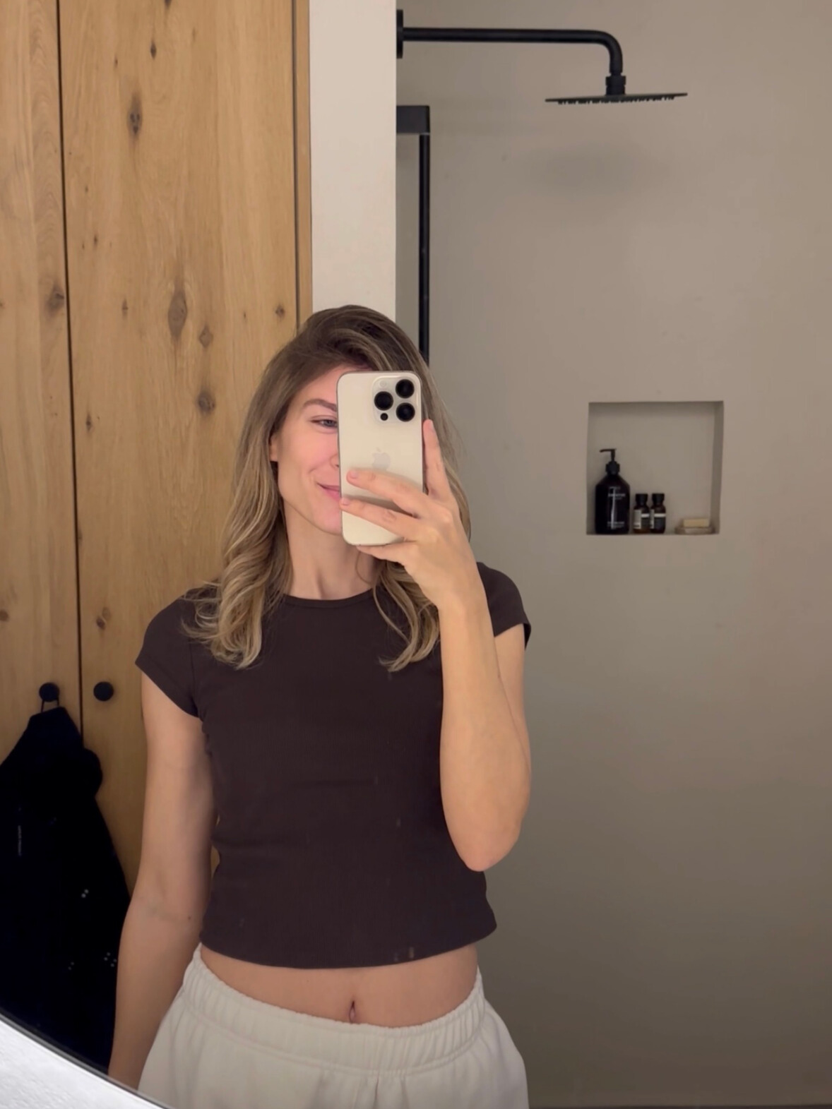 Frau im Spiegel in einem Badezimmer mit minimalistischem Design